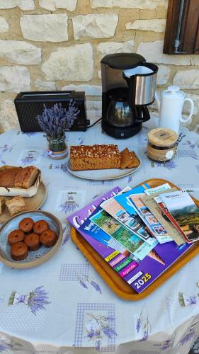 une table avec des pâtisseries et du pain dessus dans l'établissement Chambres chez l'habitant, à Montbrun-les-Bains