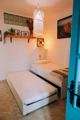 two beds in a room with a room with twoermottermott at Um Lugar ao Sol Beach House Azenhas do Mar in Sintra