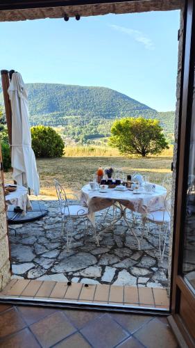 une table et des chaises sur une terrasse avec vue dans l'établissement Chambres chez l'habitant, à Montbrun-les-Bains
