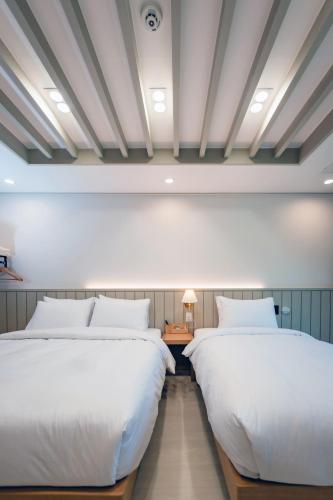 two beds in a room with white ceilings at Seorak Hotel Misong in Yangyang