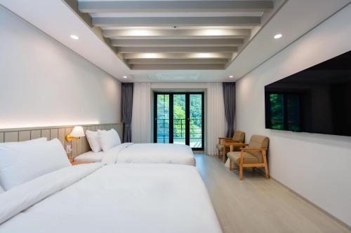 a hotel room with two beds and a television at Seorak Hotel Misong in Yangyang