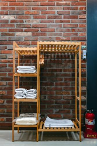 a set of three wooden shelves with white towels at Seorak Hotel Misong in Yangyang