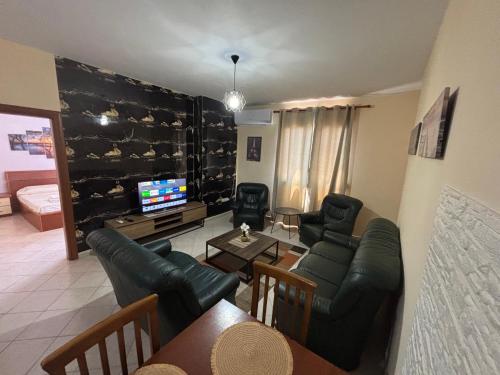 a living room with black leather furniture and a television at Balcony on the sea in Durrës