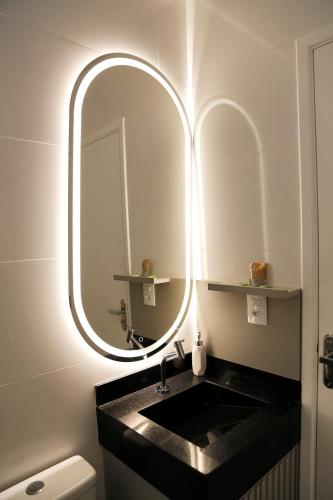 a bathroom with a sink and a large mirror at Comforto e tranquilidade in Franca