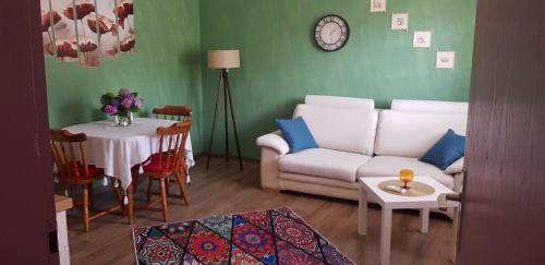 a living room with a white couch and a table at Apartment Dukat Vršac in Vršac