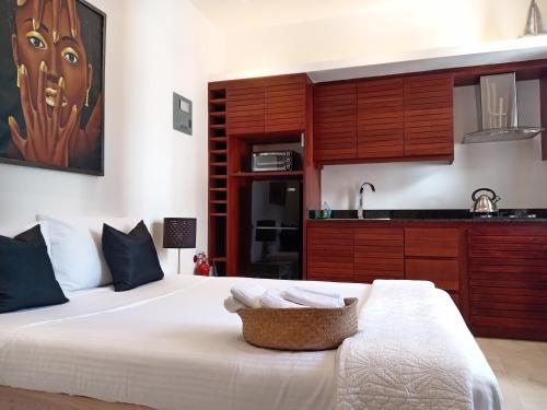 a bedroom with a large white bed and a kitchen at Boutique Hotel Casa Grande, Chocolate Paradise, Estudio superior con Cocina in Santo Domingo