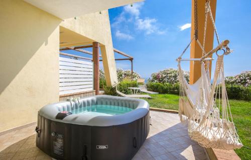 a hot tub on a patio with a swing at Amazing Home In Belmonte Calabro in Belmonte Calabro