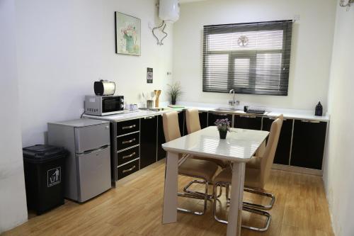 a small kitchen with a white table and a table and chairs at Royal Suites Muscat in Ma‘ābīlah