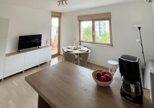 a living room with a kitchen with a table and a television at Montehome sea view in Becici