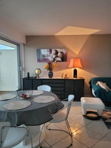 une salle à manger avec une table, des chaises et un canapé dans l'établissement Bleu horizon Canet, à Canet