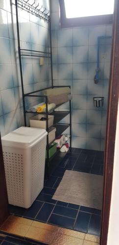 a bathroom with a blue tiled floor and a basket at Apartment Dukat Vršac in Vršac