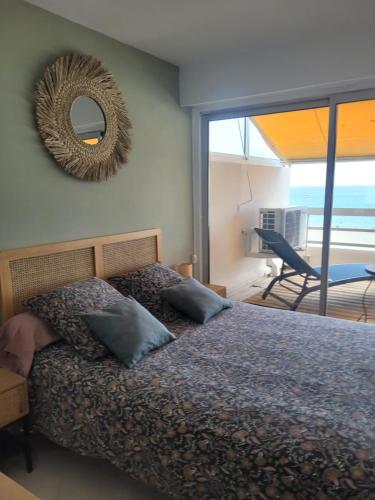 une chambre avec un lit avec un miroir au mur dans l'établissement Bleu horizon Canet, à Canet