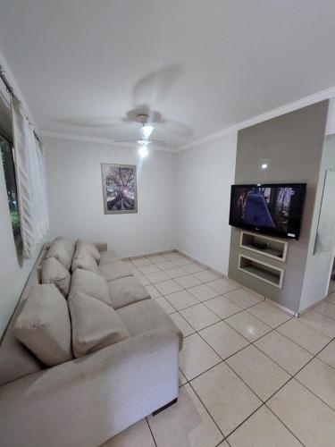 a living room with a couch and a flat screen tv at diRoma Fiori - Apartamentos JN in Caldas Novas