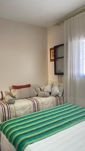 a room with two beds and a tv and a couch at mehek in Asilah