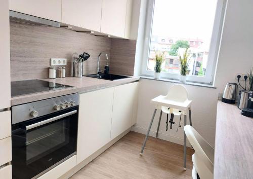 a kitchen with white cabinets and a sink and a stove at Top-Lage ideal für Teams & Familien mit 6 Personen in Neu Ulm