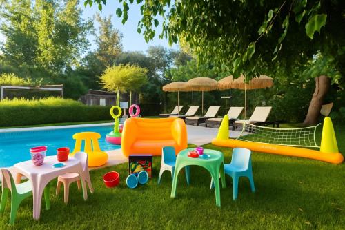 a group of plastic chairs and tables and a pool at Villa Small Paradise private pool, jacuzzi, BBQ, complete privacy in Ialyssos
