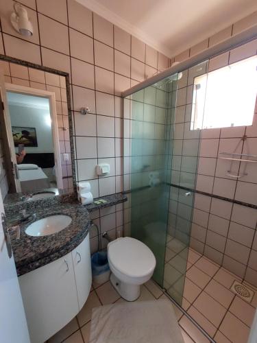 a bathroom with a toilet and a sink and a shower at diRoma Fiori - Apartamentos JN in Caldas Novas