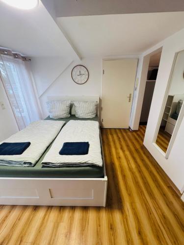 a bed in a room with a clock on the wall at Apartment mit Balkon an der Mosel in Koblenz-Güls in Koblenz
