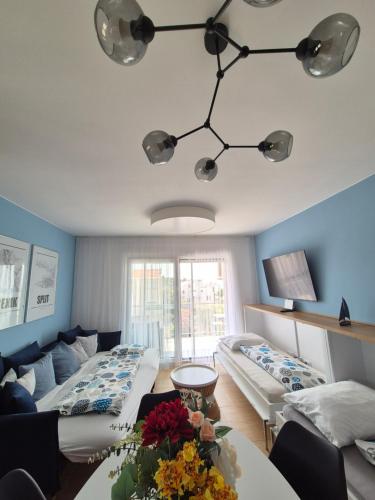 a living room with two beds and a table at Blue Breeze Apartments in Privlaka