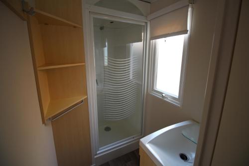a bathroom with a shower and a sink at Land's Hause Bungalows par La Conciergerie Française Emplacement S4 in Pataias