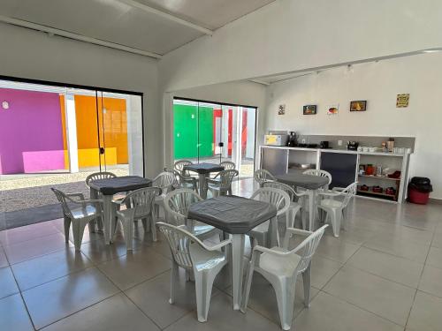a room with tables and chairs and a kitchen at Zizi Home Comfort in Chapada dos Guimarães