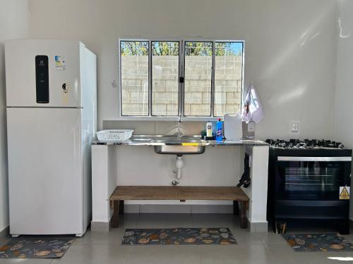 a kitchen with a counter and a sink and a refrigerator at Zizi Home Comfort in Chapada dos Guimarães