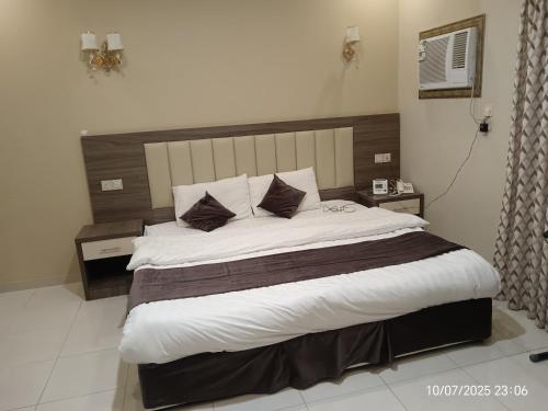 a bedroom with a large bed in a room at نيلوفر للشقق المخدومة in Yanbu