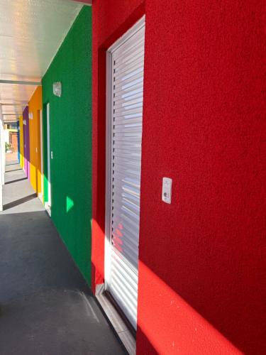 a red and green wall with a door in a hallway at Zizi Home Comfort in Chapada dos Guimarães