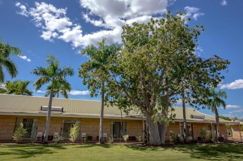 a building with palm trees in front of it at The Kimberley Grande Resort in Kununurra