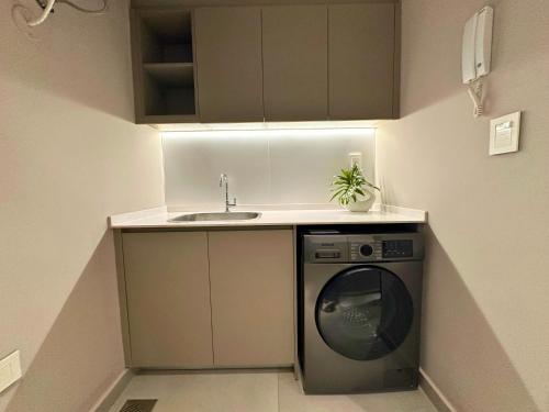a small kitchen with a washing machine and a sink at ABIBA Apart-Hotel & SPA in Asuncion