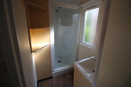 ein kleines Badezimmer mit Dusche und Waschbecken in der Unterkunft Land's Hause Bungalows par La Conciergerie Française Emplacement S5 in Pataias