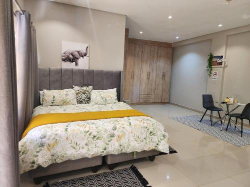 a bedroom with a bed and a table and chairs at Eastern Road Executive Suites in Harare