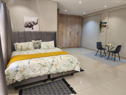a bedroom with a bed and a table and chairs at Eastern Road Executive Suites in Harare