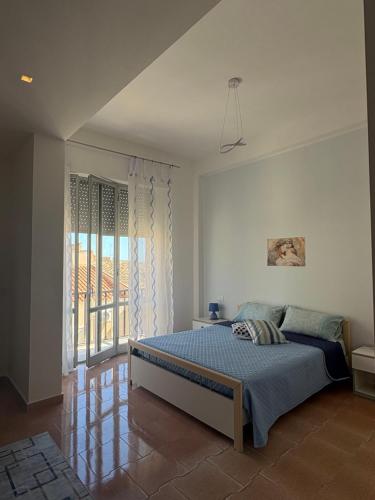 a bedroom with a bed and a large window at Casa Puccia in Pachino