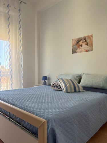 a bedroom with a bed with a blue comforter at Casa Puccia in Pachino