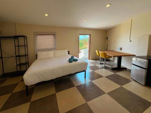 a bedroom with a bed and a kitchen with a table at Villa Autentico Aruba in Santa Cruz