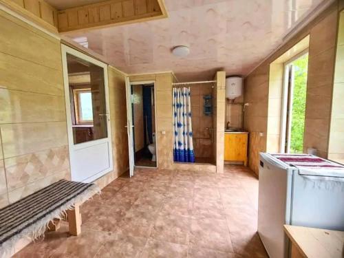 a room with a kitchen and a stove in a room at Садиба Кичера in Petrashani