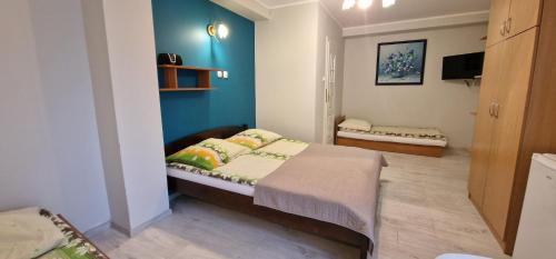 a bedroom with a bed and a blue wall at Róża Wiatrów 2 Władysławowo in Władysławowo
