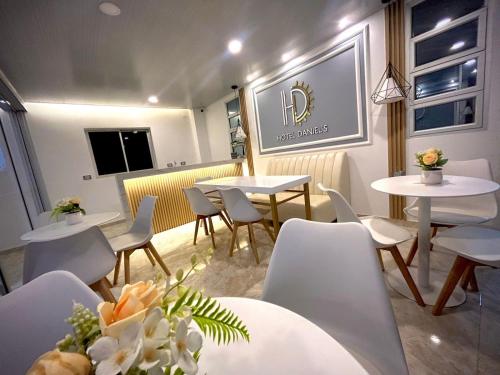 un ristorante con tavoli bianchi e sedie bianche di Hotel Daniels a Fonseca