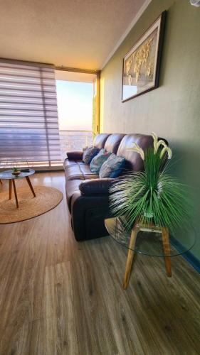 a living room with a couch and a glass table at Departamentos Amoblados Chileruca in Santiago