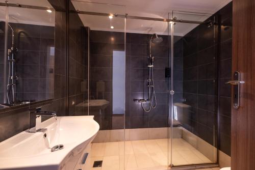 a bathroom with a shower and a sink and a tub at Stone Palace Hotel Near Athen's Airport Free Shuttle From and to Athen's Airport in Spáta