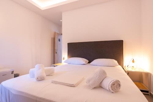 a bedroom with a large white bed with towels on it at Stone Palace Hotel Near Athen's Airport Free Shuttle From and to Athen's Airport in Spáta