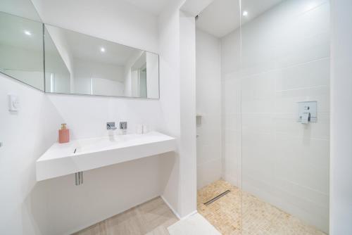 une salle de bain blanche avec un lavabo et un miroir dans l'établissement T3 luxe Marina Baie des Anges vue mer panoramique, à Villeneuve-Loubet