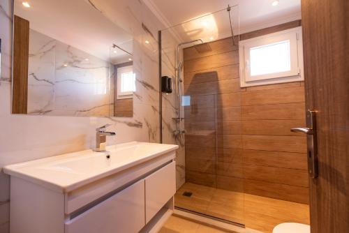 a bathroom with a sink and a shower at Stone Palace Hotel Near Athen's Airport Free Shuttle From and to Athen's Airport in Spáta