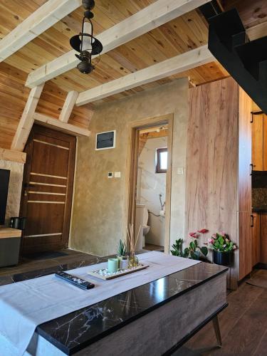 a living room with a large island in a room with wooden ceilings at Malii Rajj Žabljak in Žabljak