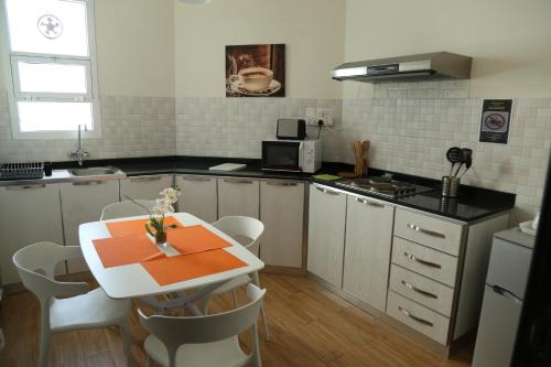 a small kitchen with a table and a microwave at Royal Suites Muscat in Ma‘ābīlah