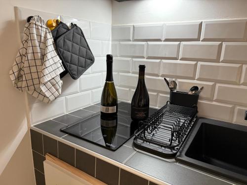 - deux bouteilles de vin assises sur un comptoir à côté d'un évier dans l'établissement Nest Love collazia Roma 900mt dal Colosseo, à Rome