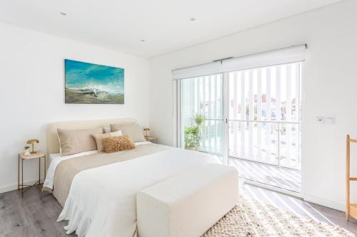 a white bedroom with a white bed and a large window at Aroeira Luxury Azul Villa, Lisboa, Beach, Surfing, Golf, Exploring, Hiking, Fishing in Charneca