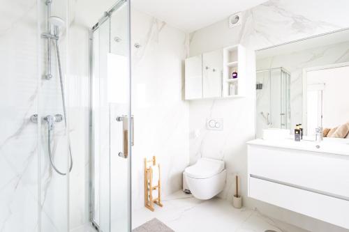 a white bathroom with a shower and a toilet at Aroeira Luxury Azul Villa, Lisboa, Beach, Surfing, Golf, Exploring, Hiking, Fishing in Charneca