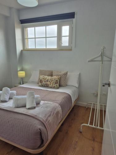 a bedroom with a large bed with a window at Laxe Piso Sol - Wifi y Netflix in Laxe